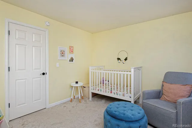 a bedroom with a couch and a baby crib