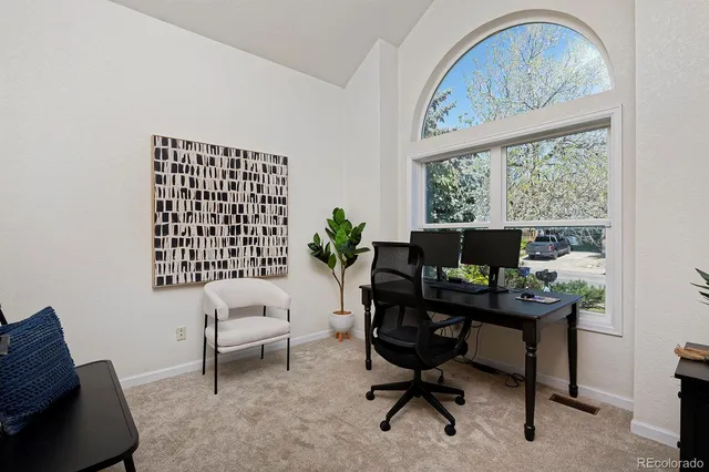 a view of a workspace with furniture and a window