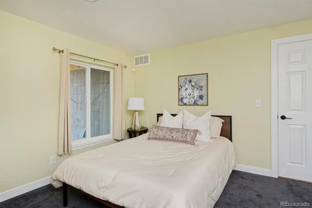 a bedroom with a bed and a lamp on table