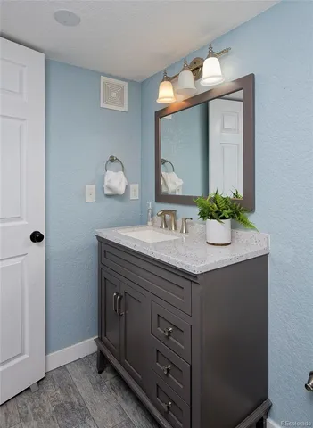 a bathroom with a granite countertop sink and a mirror