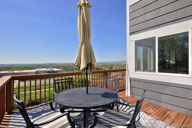 a view of a patio with a table chairs and a barbeque