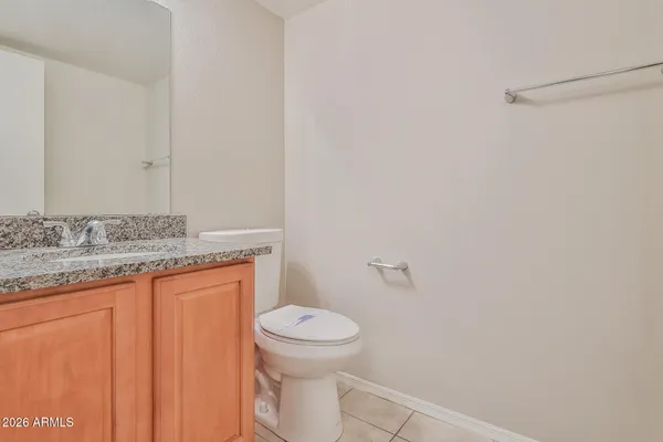 a bathroom with a granite countertop sink and a toilet