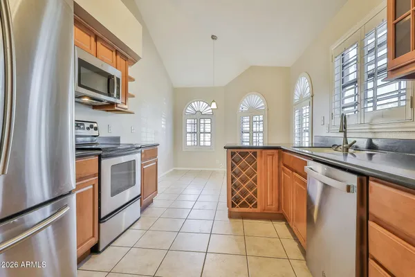 a kitchen with stainless steel appliances granite countertop a stove a sink and a refrigerator