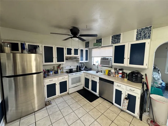 a kitchen with stainless steel appliances granite countertop a stove top oven a sink and a refrigerator