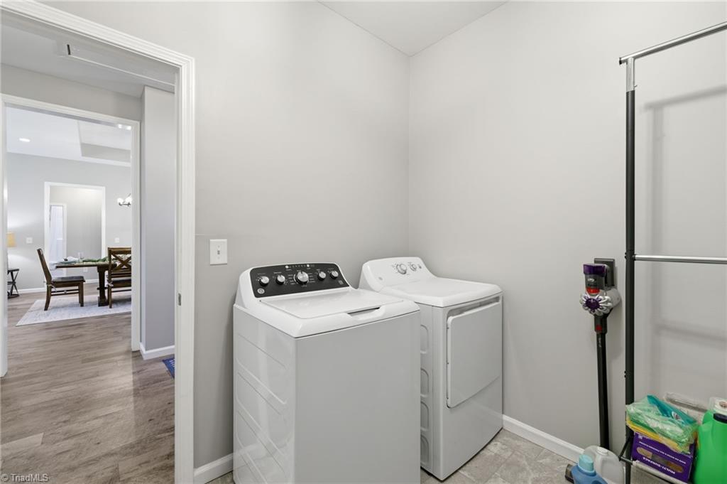 626 Bethany Road Reidsville, NC 27320 - Photo 25 of 42 Laundry room at 626 Bethany Road, Reidsville, NC 27320, Rockingham County. Full-size washer and dryer, tile floor, open to hallway with dining area visible. Bethany Community.