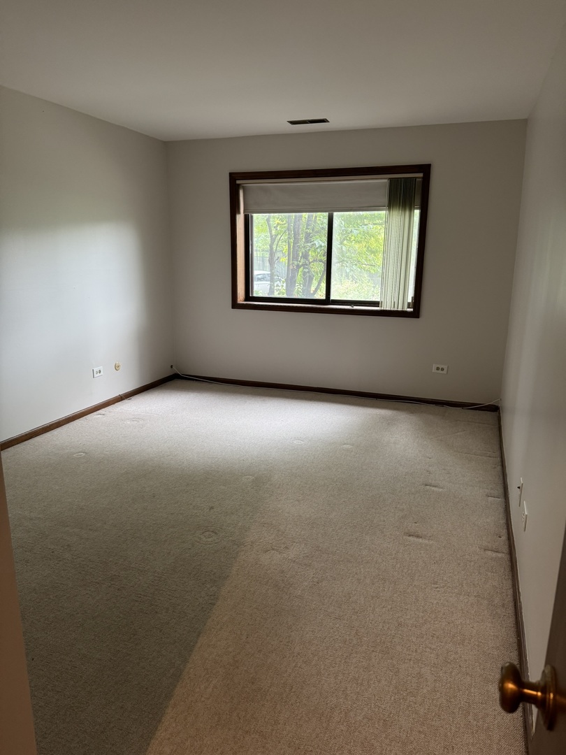 9244 Gross Point Road, Unit 103 Skokie, IL 60077 - Photo 13 of 28 an empty room with windows and closet
