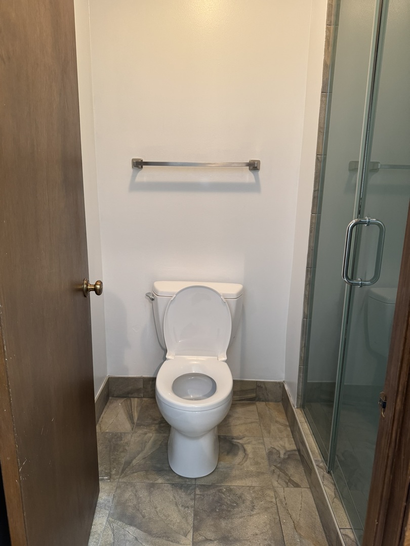 9244 Gross Point Road, Unit 103 Skokie, IL 60077 - Photo 18 of 28 a bathroom with a toilet and a shower