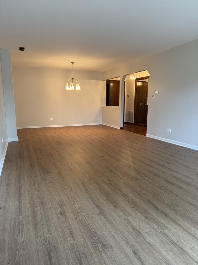 9244 Gross Point Road, Unit 103 Skokie, IL 60077 - Photo 6 of 28 a view of a room with wooden floor