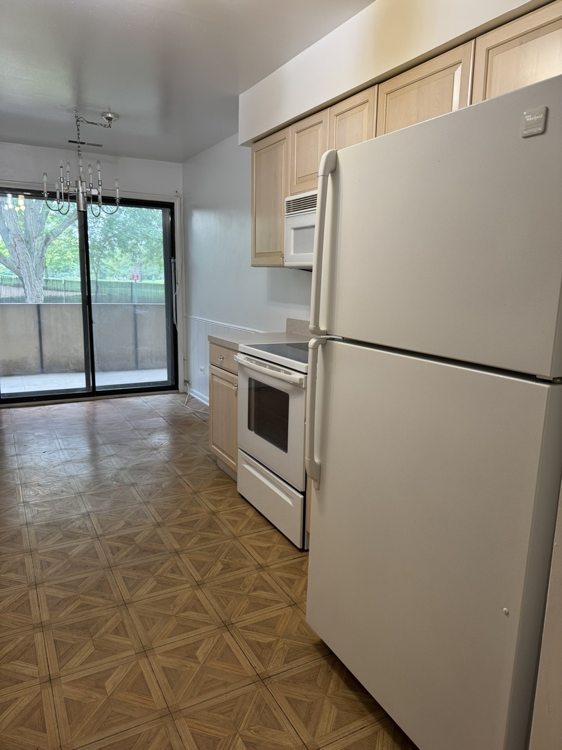 9244 Gross Point Road, Unit 103 Skokie, IL 60077 - Photo 8 of 28 a white refrigerator freezer and a stove sitting inside of a kitchen