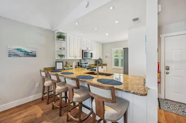 a kitchen with granite countertop a sink and a stove top oven