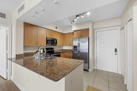 a kitchen with stainless steel appliances granite countertop a sink refrigerator and microwave