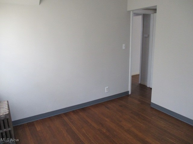 3703 Bainbridge Road Cleveland Heights, OH 44118 - Photo 7 of 16 Empty room with dark wood-type flooring and radiator heating unit