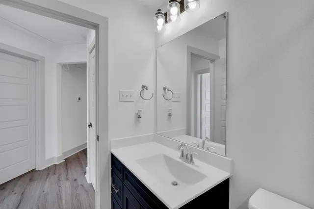 a bathroom with a bathtub shower sink vanity and toilet