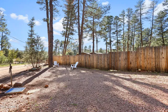 a backyard of a house with trees and wooden fence