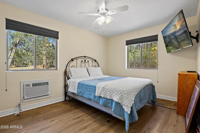 a bedroom with a bed window and a flat tv screen