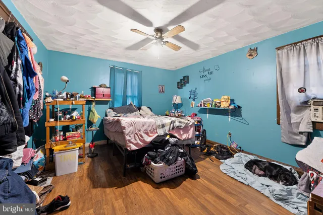 a bedroom with bed and a wooden floor