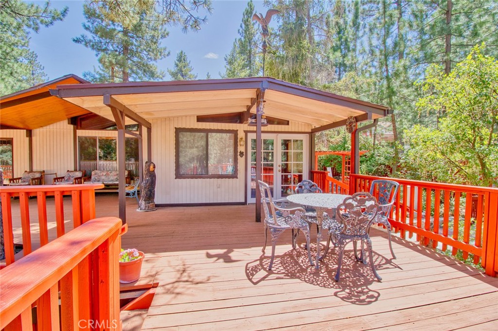 1513 Twin Lakes Road Wrightwood, CA 92397 - Photo 42 of 60 a view of a patio with table and chairs potted plants with wooden floor and fence