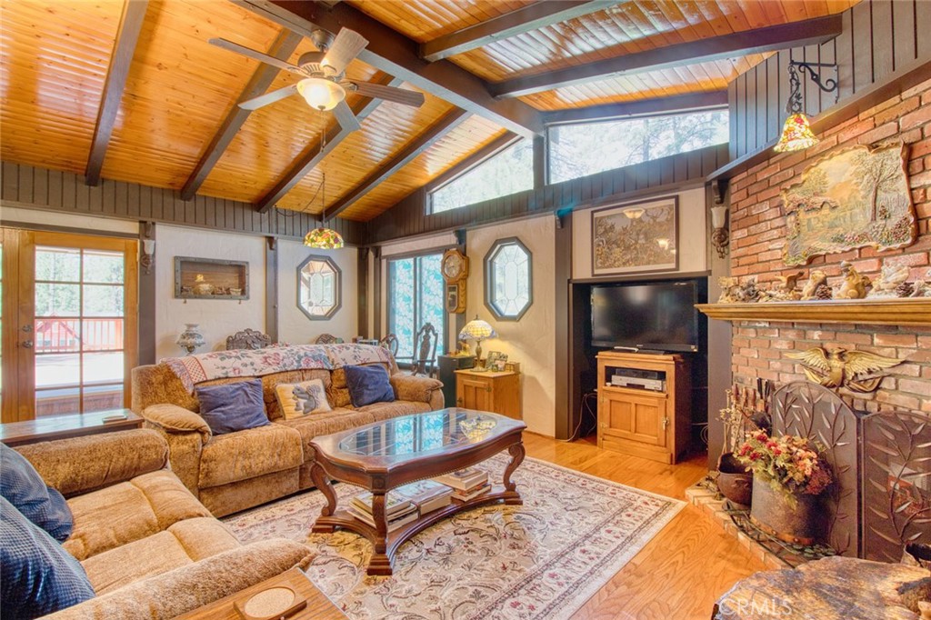 1513 Twin Lakes Road Wrightwood, CA 92397 - Photo 8 of 60 a living room with furniture a flat screen tv and a floor to ceiling window