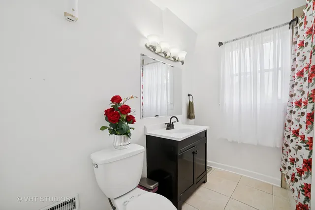 a bathroom with a sink a toilet and shower curtain