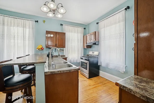 a kitchen with stainless steel appliances granite countertop a sink stove and refrigerator