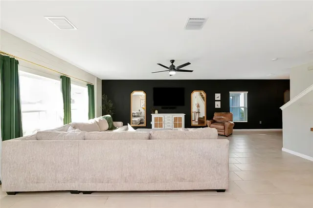 a kitchen with stainless steel appliances kitchen island granite countertop a dining table chairs and a refrigerator