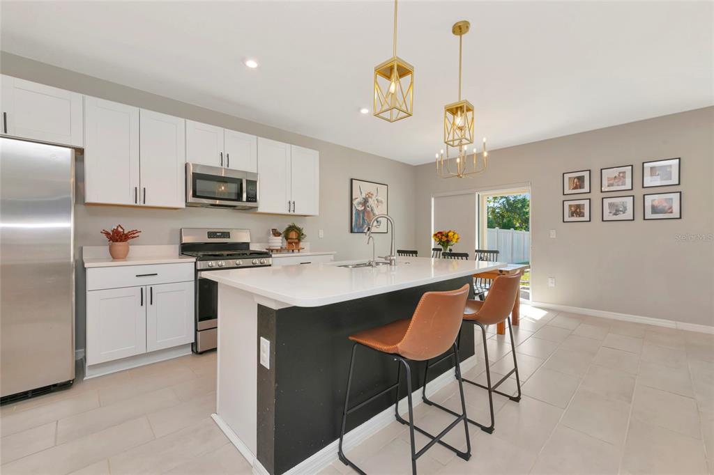 6283 Springmont Loop Palmetto, FL 34221 - Photo 13 of 68 a kitchen with kitchen island granite countertop a sink cabinets stainless steel appliances and a window