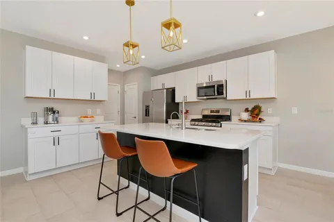 a kitchen with stainless steel appliances granite countertop a stove a refrigerator and a microwave
