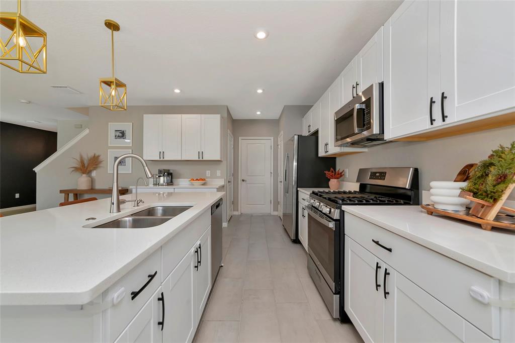 6283 Springmont Loop Palmetto, FL 34221 - Photo 17 of 68 a kitchen with stainless steel appliances granite countertop a sink stove oven and white cabinets