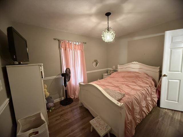 395 Austin Street Savannah, TN 38372 - Photo 17 of 32 Bedroom featuring wood-finish flooring, a decorative ceiling light fixture, and a white interior door