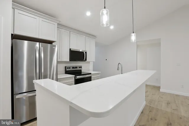 a kitchen with stainless steel appliances a refrigerator sink and microwave