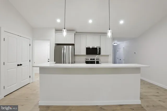 a view of kitchen with microwave and cabinets