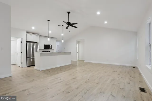 a view of kitchen with stainless steel appliances refrigerator stove microwave and cabinets