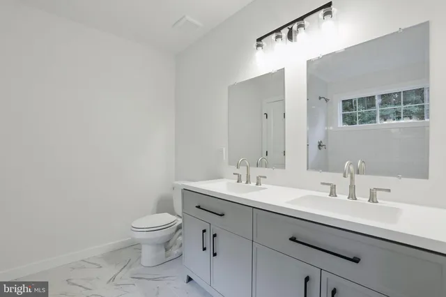 a bathroom with a toilet a sink and mirror