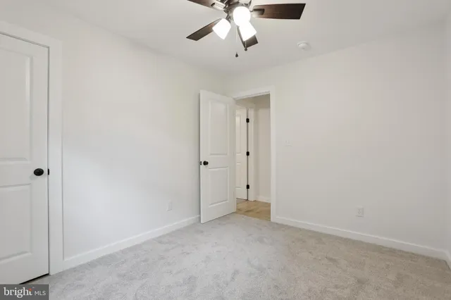 an empty room with chandelier fan