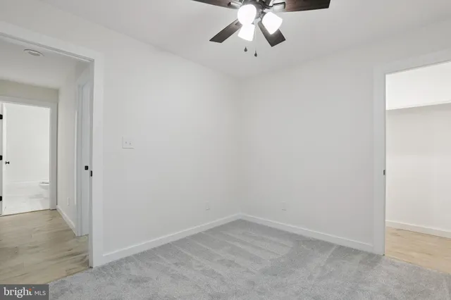 an empty room with a fan and a fan