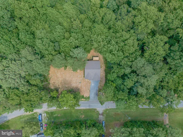 a front view of house with yard and trees in the background