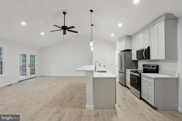 a kitchen with kitchen island a sink stainless steel appliances and cabinets