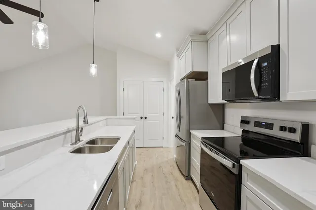 a kitchen that has a sink stainless steel appliances and cabinets