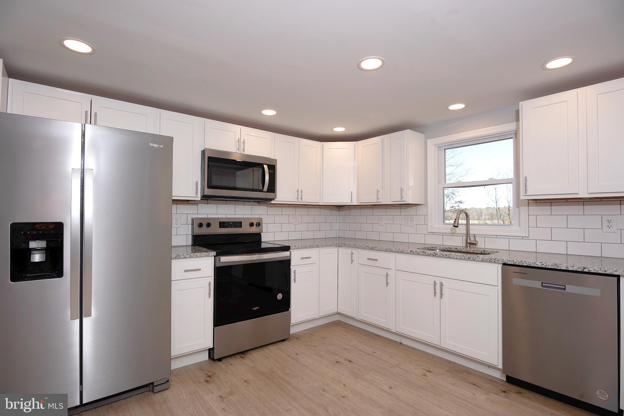 6374 Rock Hall Road Rock Hall, MD 21661 - Photo 1 of 34 a kitchen with a sink stainless steel appliances and white cabinets