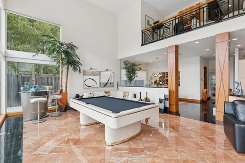 a living room with furniture a fireplace and a large window
