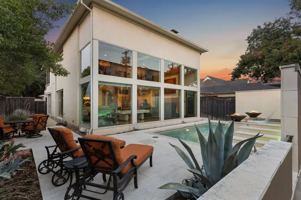a view of a patio with table and chairs and potted plants with wooden fence