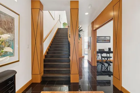a view of entryway and hall with wooden floor
