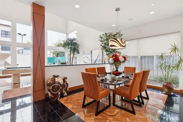 a dining room with furniture potted plants and wooden floor