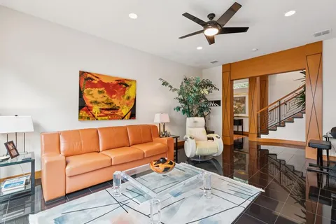 a living room with furniture ceiling fan and a rug