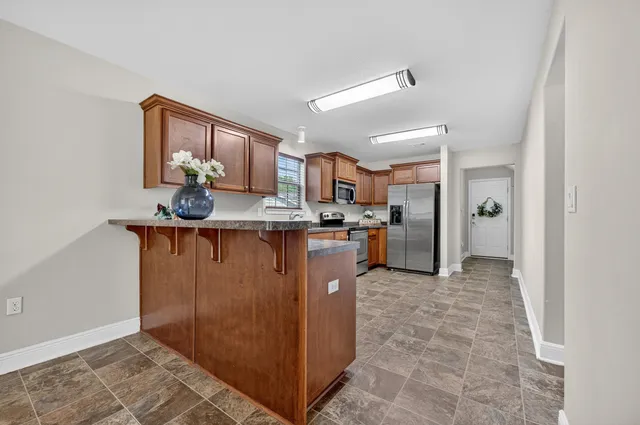 a kitchen with stainless steel appliances granite countertop a refrigerator and a sink