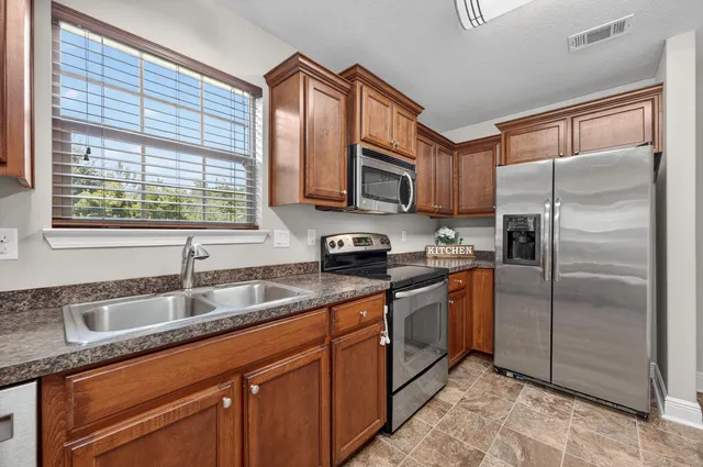 a kitchen with stainless steel appliances granite countertop a sink stove and refrigerator
