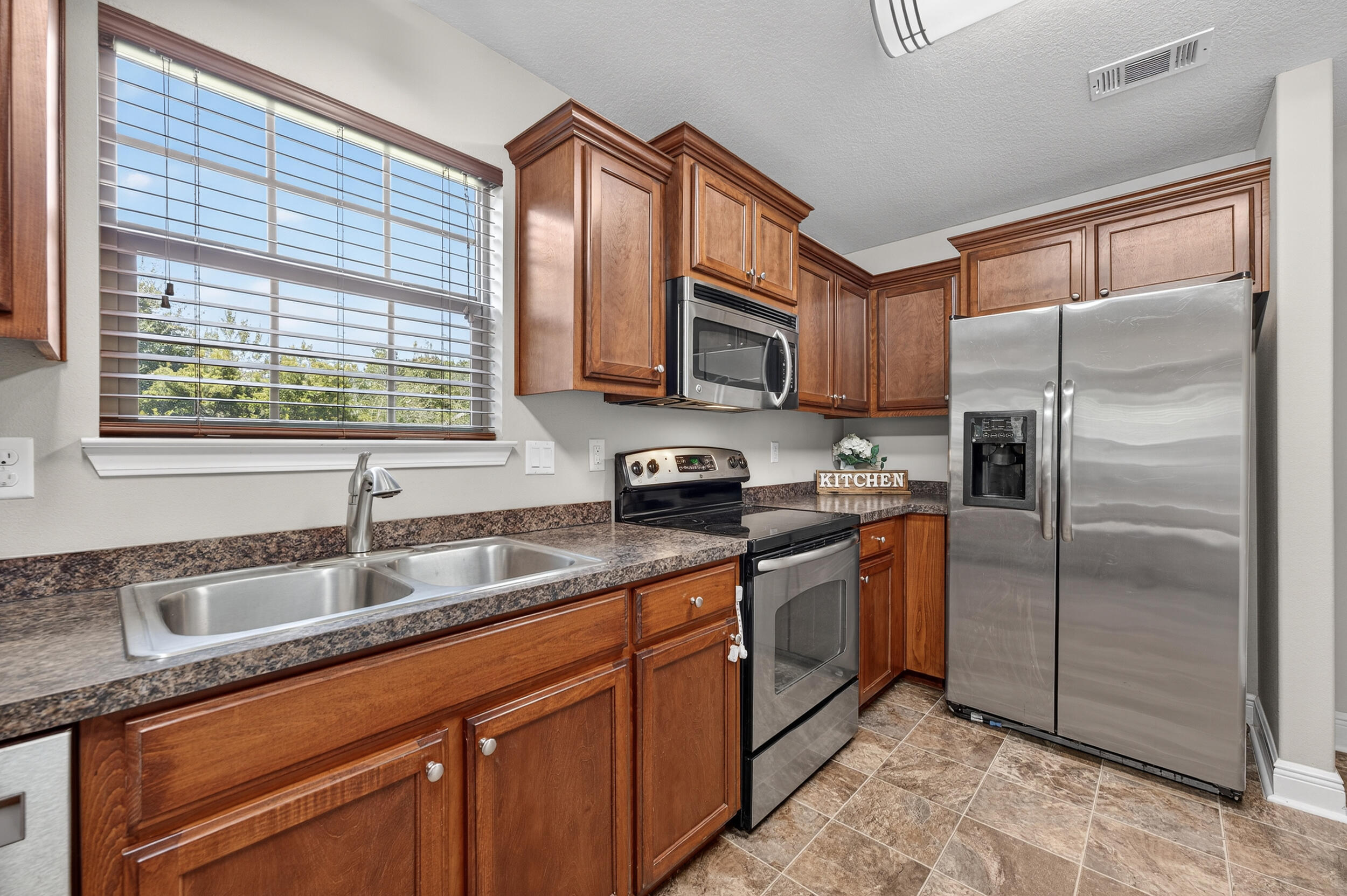 313 Gauntlet Drive Crestview, FL 32539 - Photo 17 of 44 a kitchen with stainless steel appliances granite countertop a sink stove and refrigerator