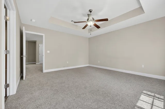 an empty room with a ceiling fan and a window