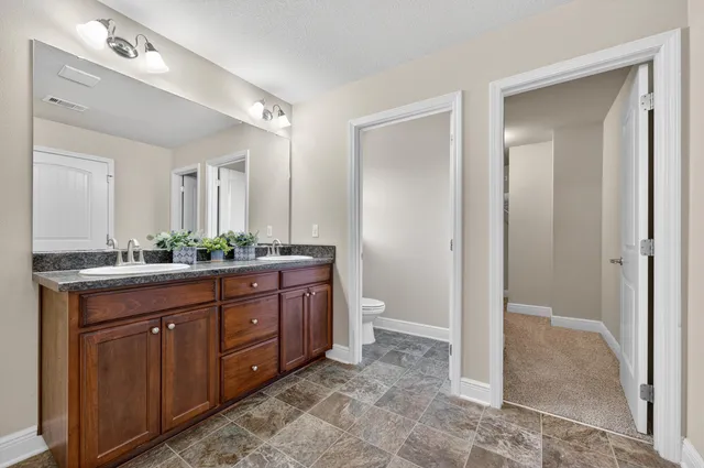 a spacious bathroom with a granite countertop sink and a mirror