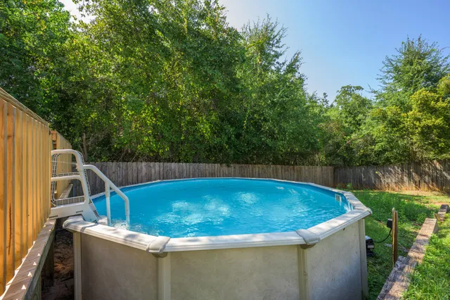 a view of a jacuzzi with a tub and trees in the background